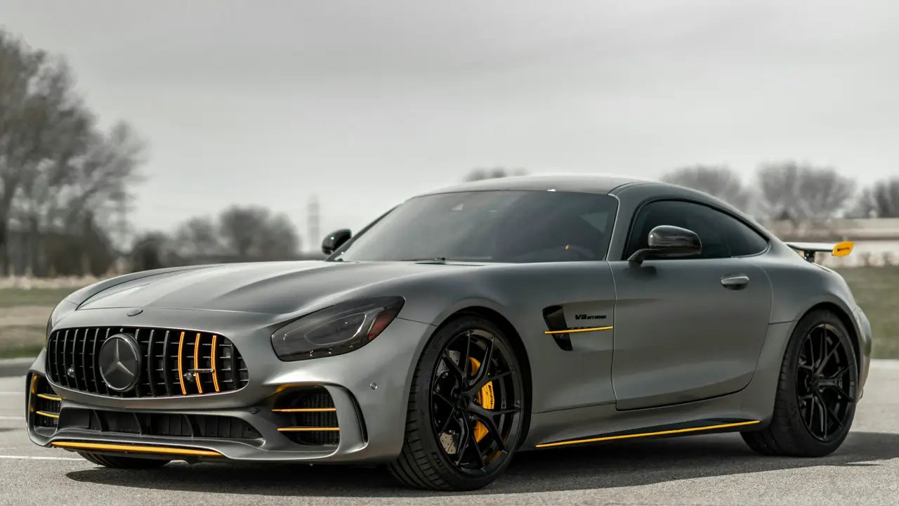 Matte grey Mercedes-AMG GT R with yellow accents parked on open tarmac
