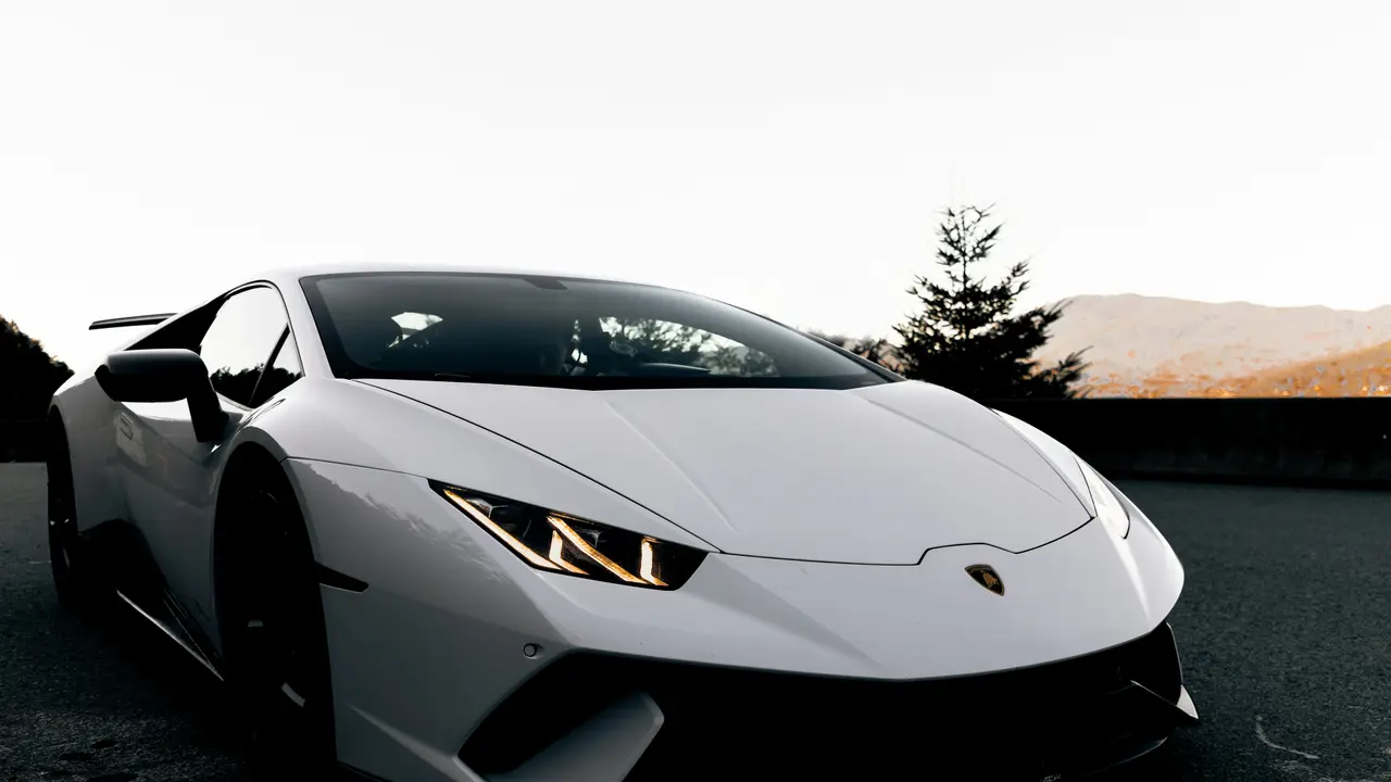 Close-up of a white Lamborghini Huracán headlight and bonnet edge